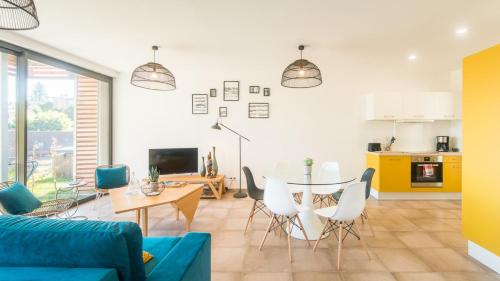 un salon avec un canapé bleu et une table dans l'établissement Les Bulles avec Jacuzzi Privatif & Parking privé, à Sarlat-la-Canéda