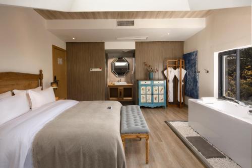 a bedroom with a bed and a tub and a sink at Dali Beauty Seaview B&B in Dali
