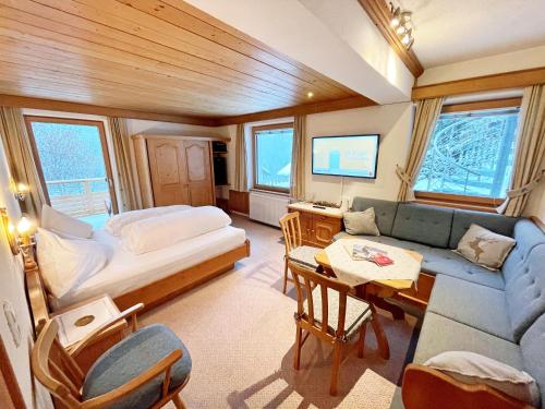 Zimmer mit einem Bett, einem Sofa und einem Tisch in der Unterkunft Alkira in Sankt Anton am Arlberg