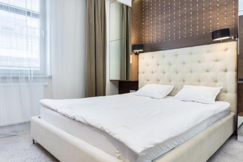 sypialnia z dużym białym łóżkiem i lustrem w obiekcie Elite Apartments Rezydencja Marina w Gdańsku