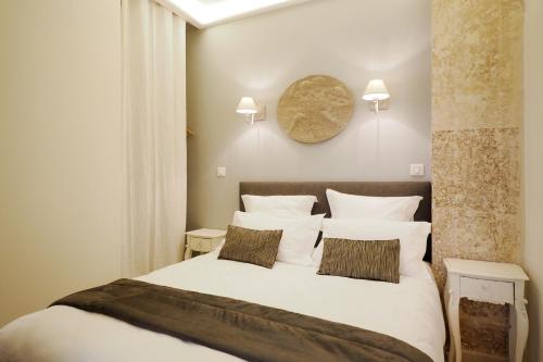 パリにあるSaint Germain Cosy ChicSuitesのベッドルーム1室(白いシーツと枕のベッド1台付)