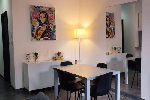 une salle à manger avec une table et des chaises blanches dans l'établissement Chalet cosy en centre-ville, au Puy-en-Velay