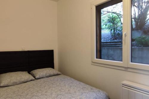 une chambre avec un lit et une fenêtre dans l'établissement Chalet cosy en centre-ville, au Puy-en-Velay