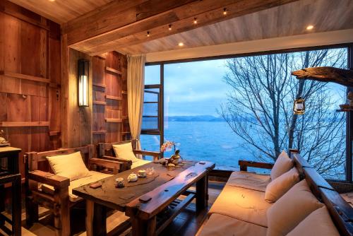 a living room with a table and a large window at Dali Beauty Seaview B&B in Dali