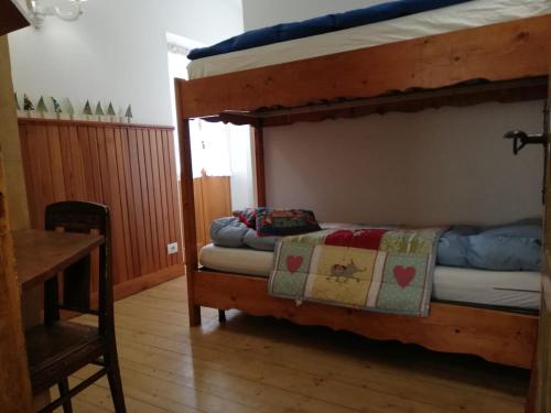 1 dormitorio con 2 literas y mesa en Cortina, the place to be!, en Cortina dʼAmpezzo