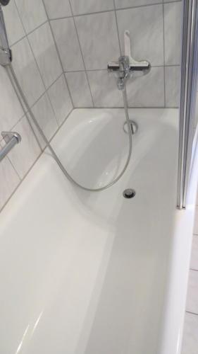 a shower with a hose attached to a white tub at Arberblick in Schöfweg
