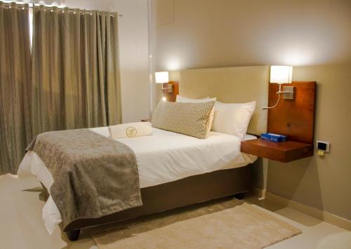 a bedroom with a bed with white sheets and pillows at Hotel Destiny in Ongwediva