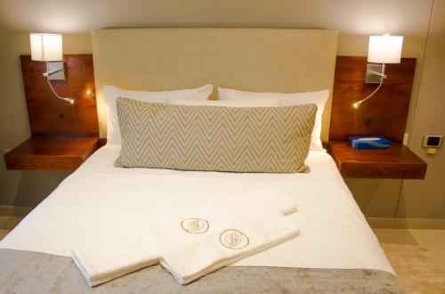 a bed with two white towels sitting on top of it at Hotel Destiny in Ongwediva