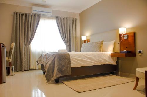 a bedroom with a large bed and a window at Hotel Destiny in Ongwediva