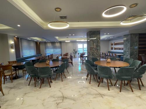 a restaurant with wooden tables and green chairs at Filippos Hotel in Halkidona