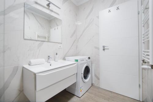 a white bathroom with a washing machine and a sink at Pinky Black Escape in Oradea