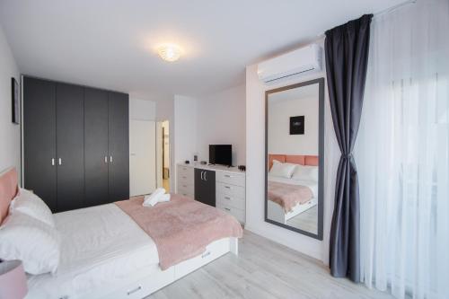 a bedroom with a bed and a large mirror at Pinky Black Escape in Oradea