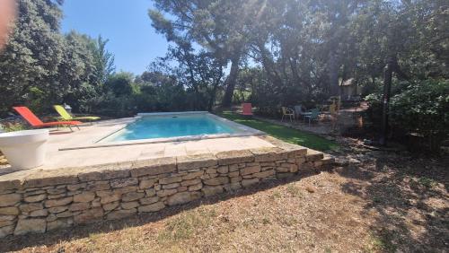 - une piscine dans une cour dotée d'un mur en pierre dans l'établissement Mas Provençal avec piscine., à Grans