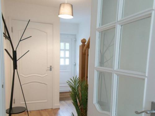 a hallway with a white door and a plant at Spacious House in Brighton with large garden and free parking in Falmer