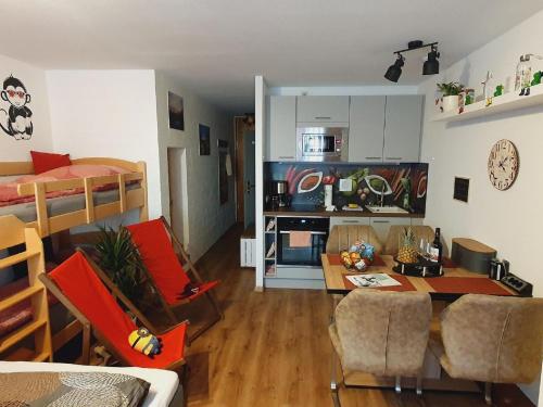 cocina y sala de estar con mesa y sillas en Ferienwohnung Winklworld 2 mit Hallenbad und Sauna inklusive aktivCARD en Sankt Englmar