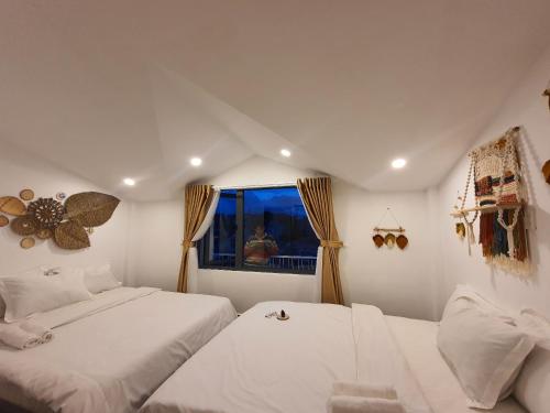 a bedroom with two beds and a window at Khách sạn Hoàng Khôi in Da Lat