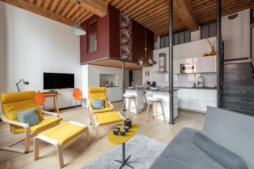 Il comprend un salon décloisonné et une cuisine avec des chaises jaunes. dans l'établissement La Bohème - Au coeur de la Croix-Rousse, à Lyon