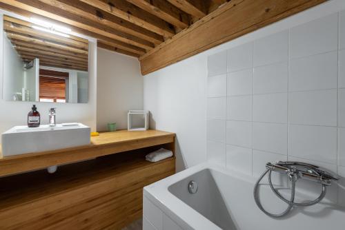 une salle de bain avec une baignoire blanche et un lavabo dans l'établissement La Bohème - Au coeur de la Croix-Rousse, à Lyon