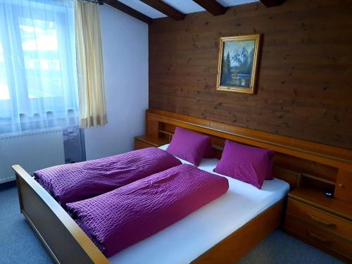 um quarto com uma cama com lençóis roxos em Haus Renate em Lermoos