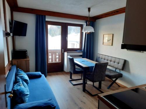 a living room with a blue couch and a table at Haus Renate in Lermoos