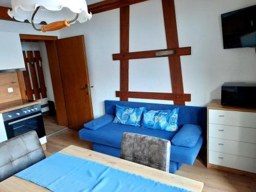 a living room with a blue couch and a table at Haus Renate in Lermoos