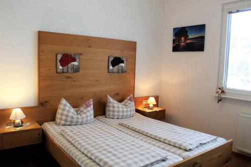 una camera da letto con letto, cuscini e finestra di Sport Rees- Ferienwohnung Ulrich a Hofsgrund