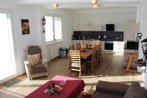 a living room with a table and a kitchen at Sport Rees- Ferienwohnung Ulrich in Hofsgrund