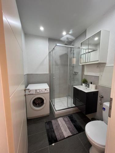 a bathroom with a shower and a washing machine at Premium Apartment 1 in Pachten