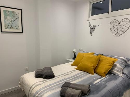 Un dormitorio con una cama con almohadas amarillas y una ventana en Apartamento con encanto y piscina, en Fuengirola