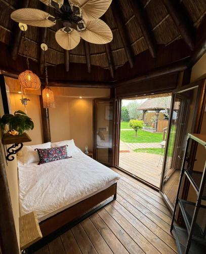 ein Schlafzimmer mit Bett und Deckenventilator in der Unterkunft Tropical bungalow suite in El Palmar