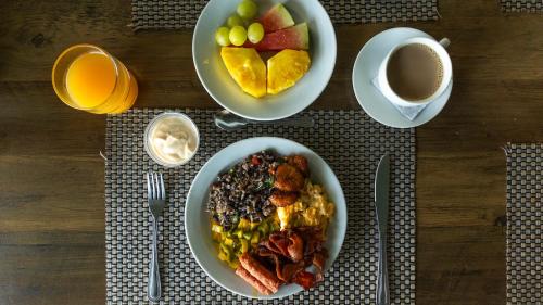 a table with plates of breakfast food and a cup of coffee at Blue Mirador Hotel Manuel Antonio in Manuel Antonio