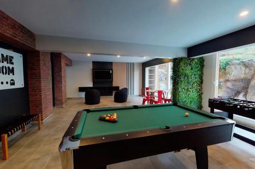 a room with a pool table and a living room at DEPARTAMENTOS ESPACIO PUCON in Pucón