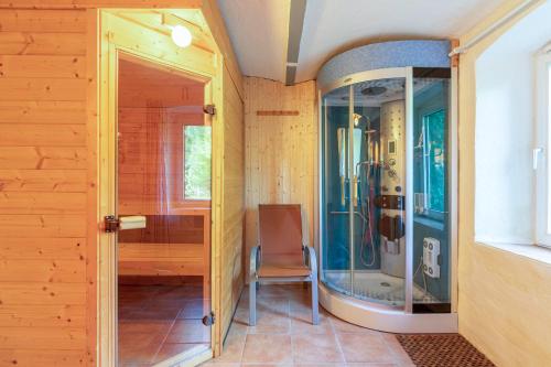 baño con ducha de cristal con silla en Alte Wassermuehle Hollebek, en Bredstedt