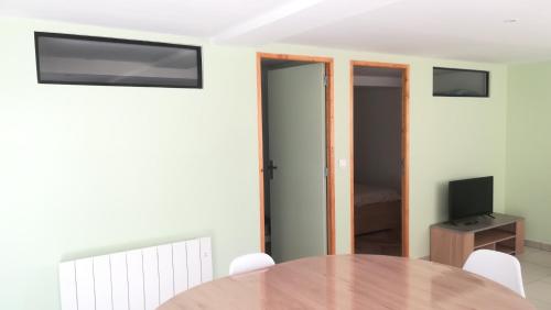 Habitación con mesa, TV y dormitorio. en Gîte de l'étang des sarcelles, en Saint-Martin-dʼAubigny