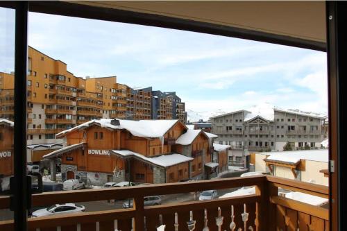 einen Balkon mit Blick auf eine verschneite Stadt in der Unterkunft Cozy and Spectacular Condo VT in Val Thorens