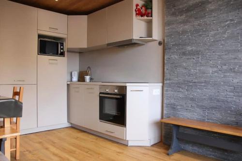 eine Küche mit weißen Geräten und einem Holztisch in der Unterkunft Cozy and Spectacular Condo VT in Val Thorens