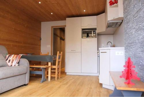 ein Wohnzimmer mit einem Sofa und einem Tisch sowie eine Küche in der Unterkunft Cozy and Spectacular Condo VT in Val Thorens