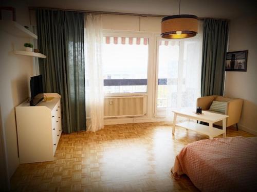 - une chambre avec un lit, une table et une fenêtre dans l'établissement T1 bel appartement proche de Genève, à Annemasse