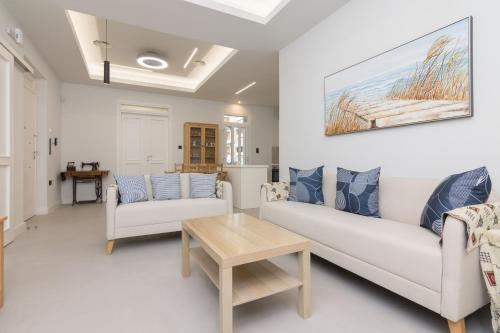 a living room with two white couches and a table at Two Bedroom Apt In Kallithea in Athens