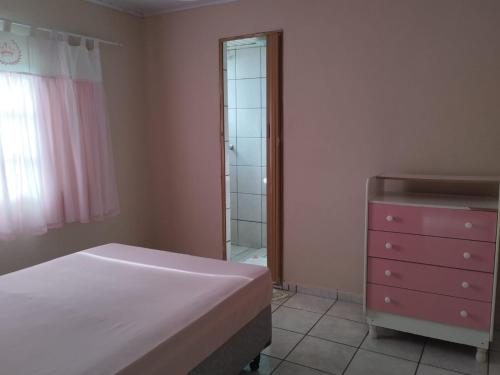 een slaapkamer met een bed, een dressoir en een spiegel bij RECANTO DA IZAURINHA in Olímpia