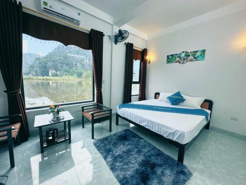 ein Schlafzimmer mit einem Bett und einem großen Fenster in der Unterkunft Ninh Binh Truong Nhan homestay in Ninh Bình