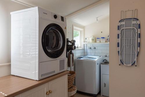 a washer and dryer on a counter in a kitchen at Mersey River Cottage ( cir 1888) Central location with Amazing Ocean and Habour Views. in Devonport