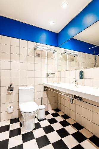 a bathroom with a toilet and a checkered floor at VICTORIA Hotel Kaunas in Kaunas