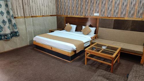 a hotel room with two beds and a table at Phoenix Hotel & Restaurant in Kota Bāgh