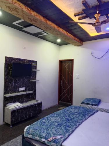 a bedroom with a bed and a flat screen tv at STAR HOTEL in Bahādurgarh