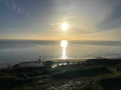 a view of the sun setting over the water at The Q Hotel in Shanklin
