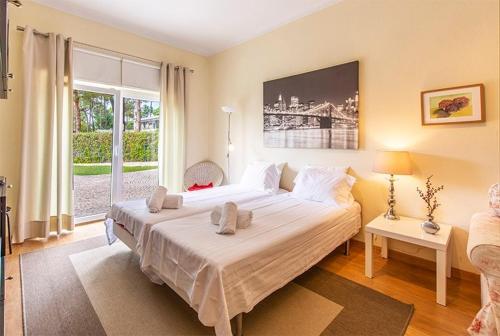 um quarto com uma cama grande e uma janela grande em Villa Alecrim em Aroeira
