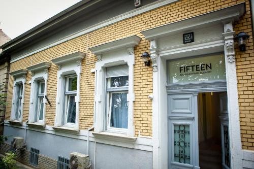 un magasin devant un bâtiment en brique avec un panneau indiquant quinze dans l'établissement Fifteen Boutique Rooms Budapest with Self Check-In, à Budapest