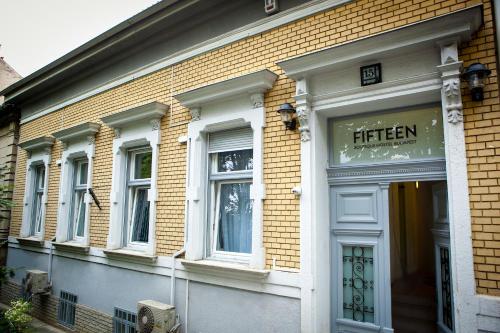 uma loja na frente de um edifício de tijolos com um cartaz que diz quinze em Fifteen Boutique Rooms Budapest with Self Check-In em Budapeste