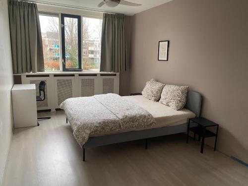 een kleine slaapkamer met een bed en een raam bij Rotterdam City Center in Rotterdam